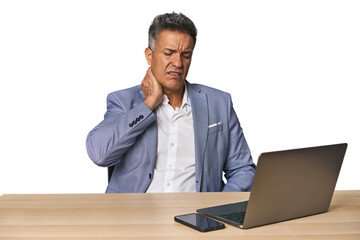 Elegant businessman at desk with laptop suffering neck pain due to sedentary lifestyle.