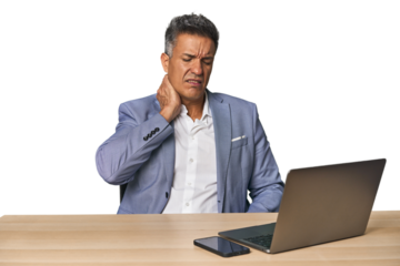 Elegant businessman at desk with laptop suffering neck pain due to sedentary lifestyle.