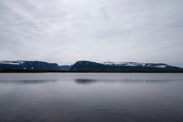 Peaceful landscape of Gros Morne National Park with Western Brook Pond and snowy mountains - obrazy, fototapety, plakaty
