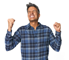 Middle-aged Latino man raising fist after a victory, winner concept.