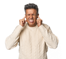 Middle-aged Latino man covering ears with hands.