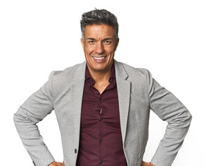 Middle-aged Latino man confident keeping hands on hips.