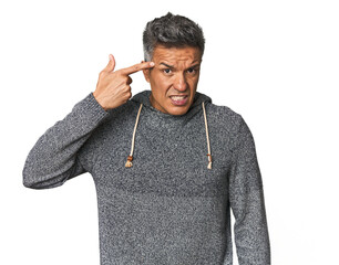 Middle-aged Latino man showing a disappointment gesture with forefinger.