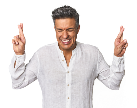 Middle-aged Latino man crossing fingers for having luck