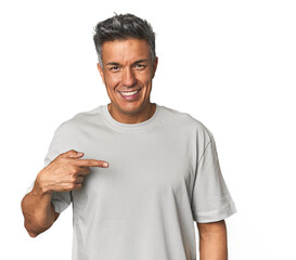 Middle-aged Latino man person pointing by hand to a shirt copy space, proud and confident
