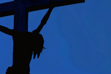 AI generated illustration of Jesus crucified on a cross in the dark - obrazy, fototapety, plakaty