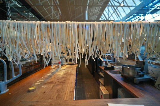 Closeup of fresh pasta hanging on a pole - Powered by Adobe