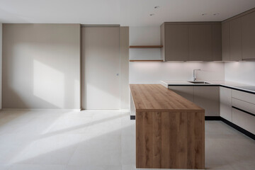 Interior of a modern kitchen with a wooden table or worktop. Everything is new and there are no objects around - 785163841