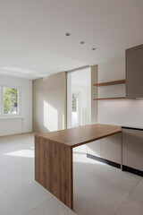 Interior of a modern kitchen with a wooden table or worktop. Everything is new and there are no objects around - 785163849