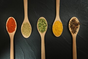 Closeup shot of wooden spoons with different spices - obrazy, fototapety, plakaty