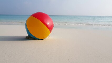 Obraz premium Colorful ball on a sandy beach