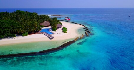 Aerial drone shot of a populated island in the Maldives washed by the Indian Ocean