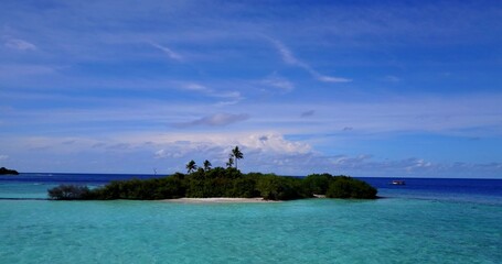 Aerial drone shot of an untouched island in the Maldives washed by the Indian Ocean