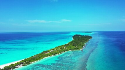 Aerial shot of green island land in the tranquil water in Kuramathi Maldives resort