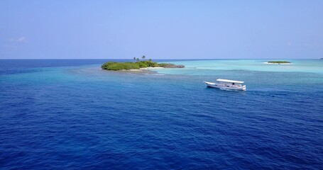 Aerial view of a boat sailing near an island in the Maldives
