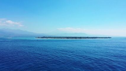 Obraz premium Scenic view of an island against a turquoise sea on a sunny day
