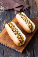 Hot dogs with grilled sausages, ketchup, mustard, fried onions and cucumbers. Fast food.