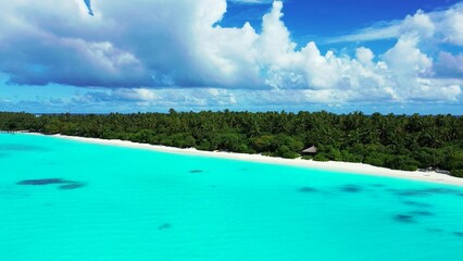 Aerial view of an island covered with greenery against a turquoise sea on a sunny day