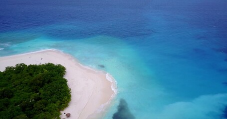 Aerial view of a small tropical island with a white sandy beach and turquoise water
