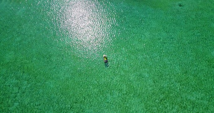 Aerial top view of a boat in a green water