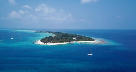 Aerial view of a small tropical island with a white sandy beach and blue transparent water