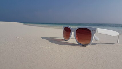 White sunglasses on a sandy beach