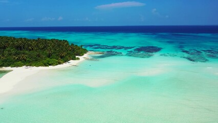 Aerial view of the azure water of the ocean and a green island in Asia