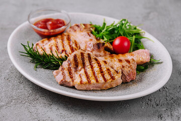 Grilled pork chops on ceramic plate with herbs