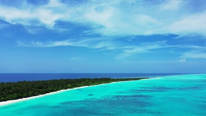 Aerial scenic view of turquoise water and a small island in the Maldives