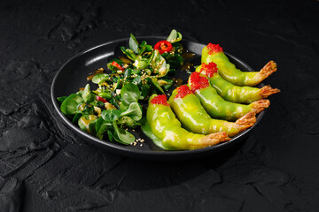 Gourmet shrimp avocado salad on dark plate