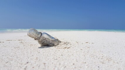 Beautiful view of a small glass bottle on the sand by the sea in Asia