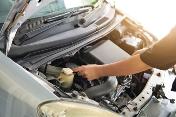 Close-up image of man inspecting and checking car engine. Transportation concept.