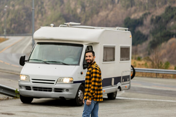 Smiling Man on Road Trip with White Camper Van