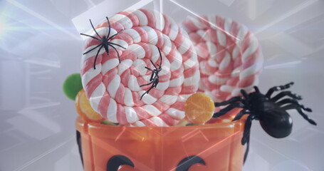 Obraz premium Glowing tunnel against spiders and candies in halloween pumpkin bucket against white background