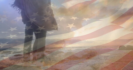 Fototapeta premium Image of flag of united states of america over couple standing on beach