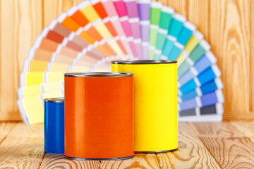 Painter and decorator work table with house project, color swatches, painting roller and paint brushes