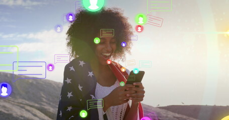 Image of media icons over happy biracial woman using smartphone - Powered by Adobe