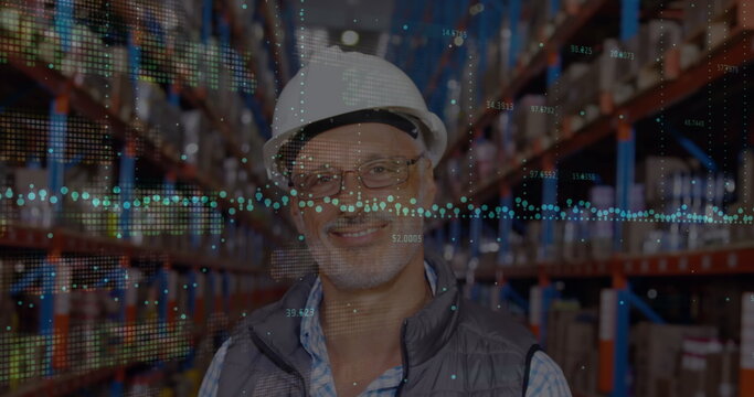 Image of financial graphs over happy senior caucasian male warehouse worker