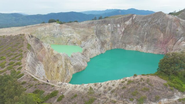 Aerial shot of Kelimutu crater national park Indonesia. Aerial top flight over volcano color lake of perfectly round shape. 