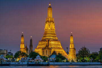 Wat Arun stupa, a significant landmark of Bangkok, Thailand, stands prominently along the Chao Phraya River, with a beautiful twilight. - 785191449