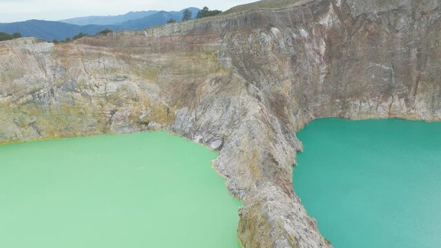 Aerial shot of Kelimutu crater national park Indonesia. Aerial top flight over volcano color lake of perfectly round shape. 