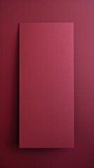 Maroon background with dark maroon paper on the right side, minimalistic background, copy space concept, top view, flat lay
