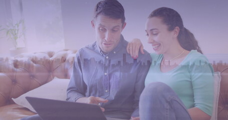 Image of 5g text and cityscape over caucasian couple using laptop