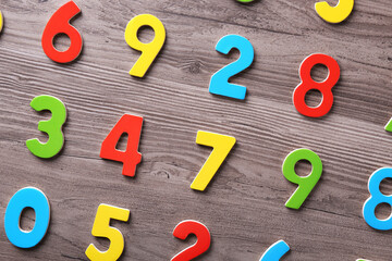 Colorful numbers on wooden school desk, flat lay