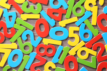 Colorful numbers on wooden school desk, top view