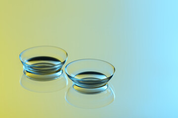 Pair of contact lenses on mirror surface. Space for text