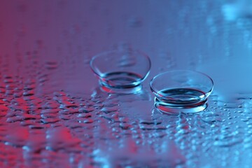 Pair of contact lenses on wet mirror surface. Space for text