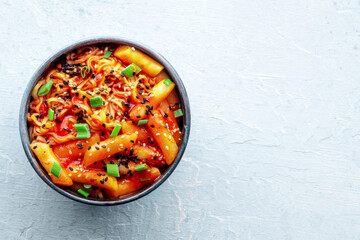 Rabokki, tteokbokki or topokki with ramen, Korean street food, spicy rice cakes in red pepper gochujang sauce, shot from the top with copy space