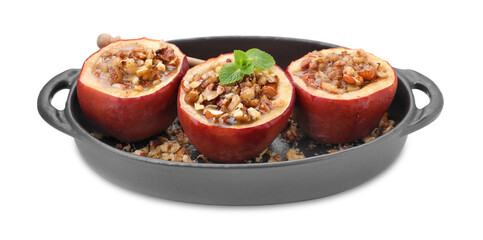 Tasty baked apples with nuts, honey and mint in baking dish isolated on white