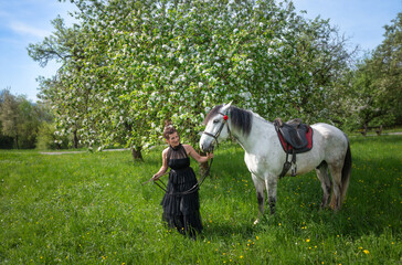 Frau mit Pferd in der Frühlingswiese
